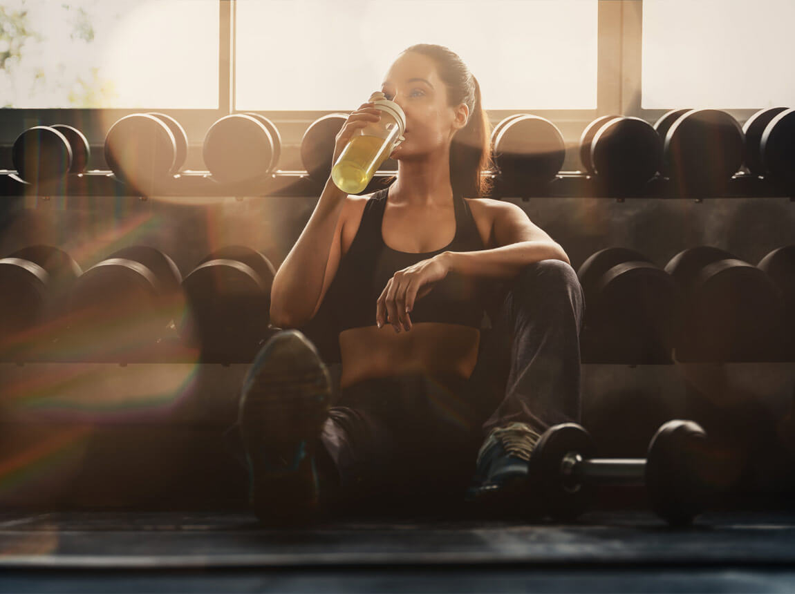 nő egy üveg itallal edzés közben 