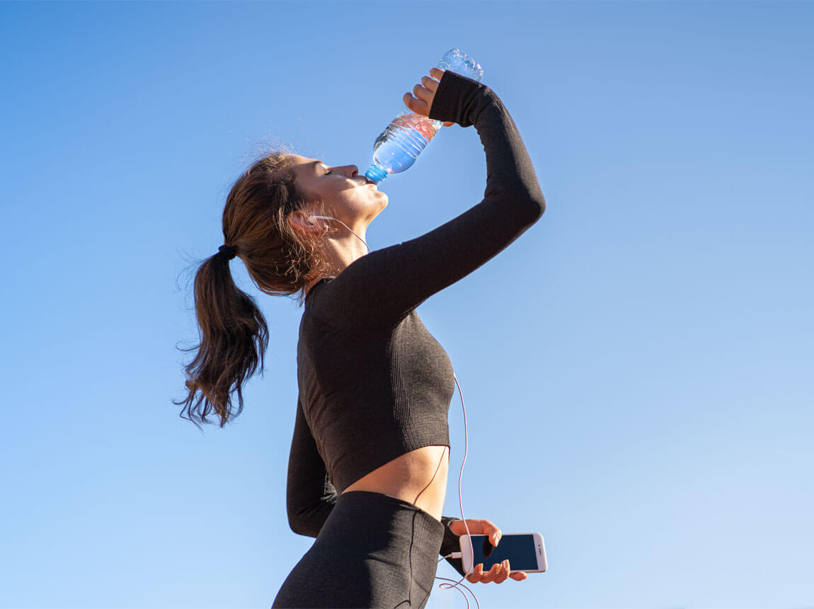 nő egy palack vízzel egy forró napon