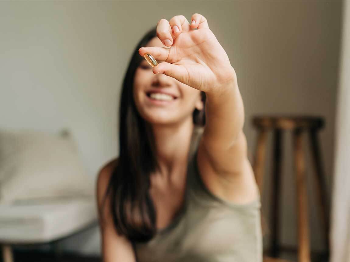 egy nő egy omega-3 kapszul&aacute;val 