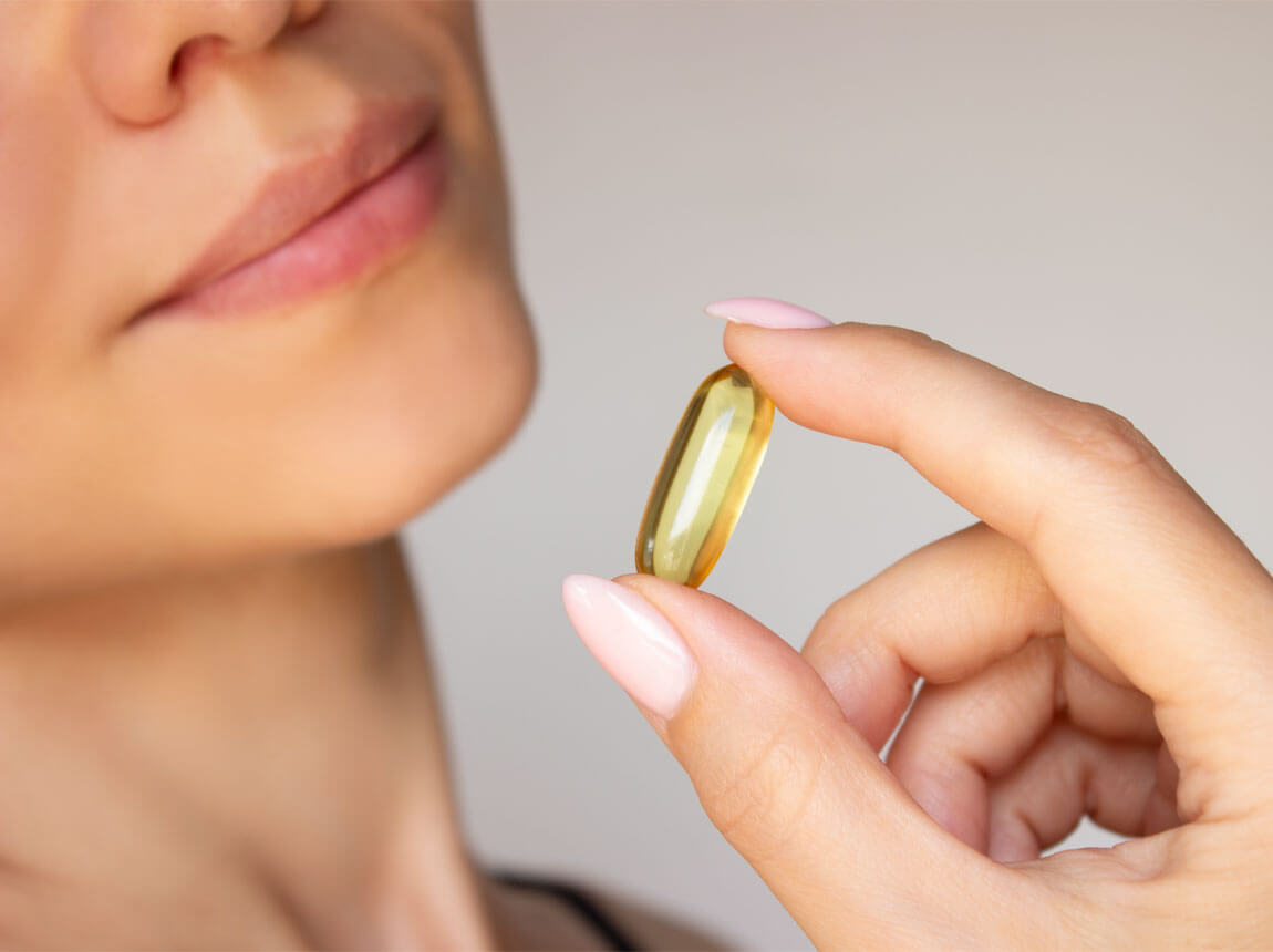 omega-3 kapszul&aacute;t szedő nő