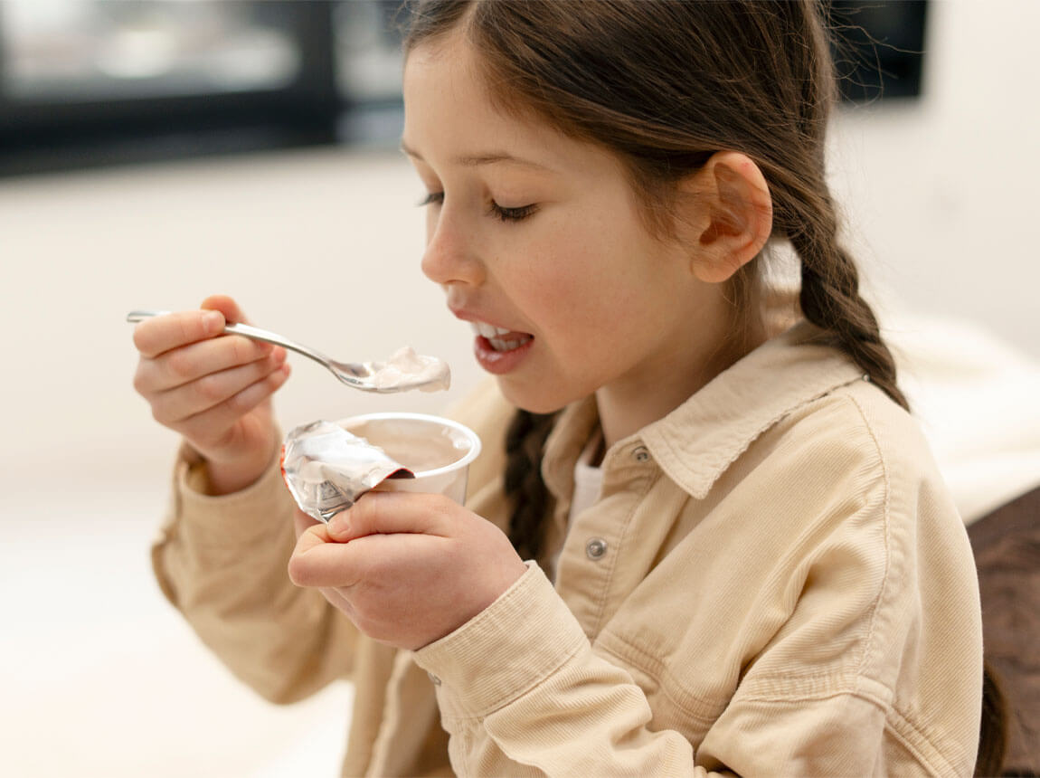lány joghurttal - probiotikumok gyerekeknek